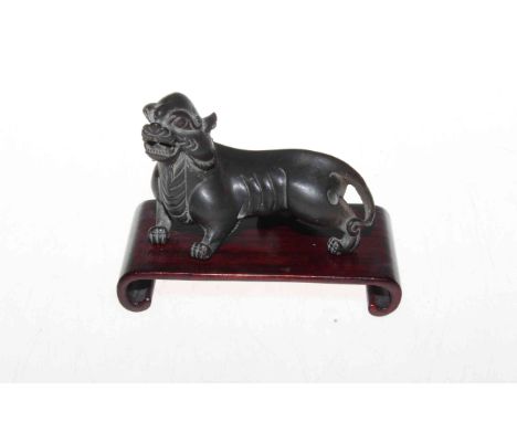 Chinese bronze tiger on wood stand, 10cm length.