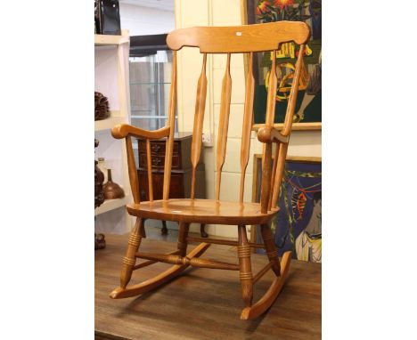 Light wood finish rail back rocking chair.