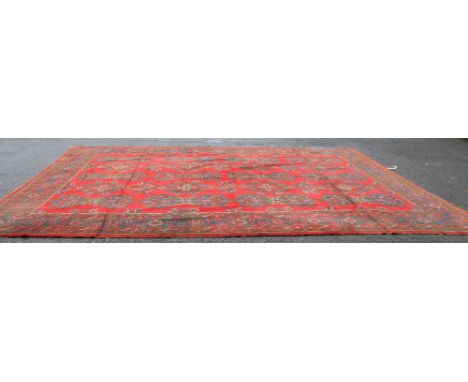 Turkish Uskak red ground carpet, the four rows of geometric lozenges within a triple border, 540cm x 400cm.