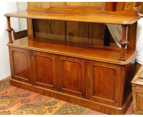 Victorian mahogany buffet with moulded shelf on fluted columns above four arched panel doors, on a plinth base, 122cm high an