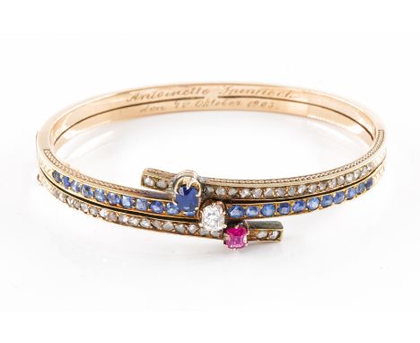 A DIAMOND, RUBY AND SAPPHIRE BANGLE, CIRCA 1900Set with three principal stones, including an old mine cut diamond, an oval sa