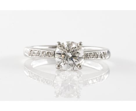 A DIAMOND RING WITH DIAMOND SET SHOULDERSThe central round brilliant cut diamond (weight 0.90 carats) in a claw setting, with