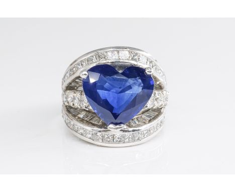 A SAPPHIRE AND DIAMOND DRESS RINGClaw set with a heart shaped blue sapphire, otherwise mounted with princess and round brilli