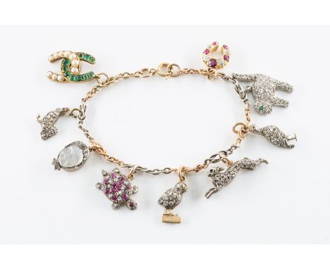 AN ANTIQUE DIAMOND AND GEM SET CHARM BRACELETFitted with nine pendants and charms, including; a ruby and diamond set tortoise