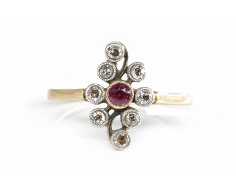 AN EDWARDIAN RUBY AND DIAMOND RINGFeaturing a central round ruby and eight further old cut diamonds, all in a rub over mille-