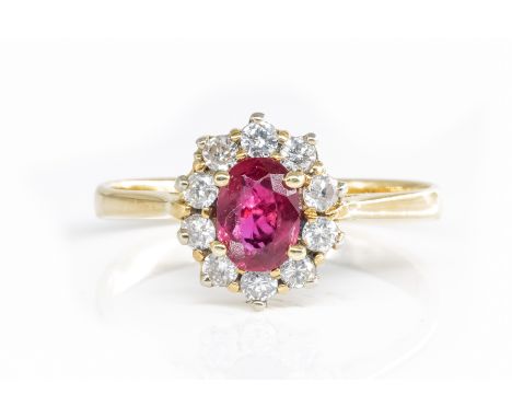 A RUBY AND DIAMOND OVAL CLUSTER RINGClaw set with the oval cut ruby at the center, within a surround of ten circular cut diam