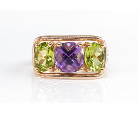 AN AMETHSYT AND PERIDOT RINGWith two oval peridots and one oval amethyst, in stamped 18k rose gold, ring size K, gross weight