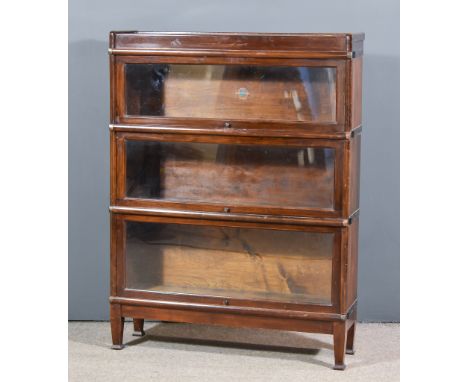 A Globe Wernicke Oak Three Tier Sectional Bookcase, with glazed rising fronts, on square tapered legs, 34ins wide x 10ins dee