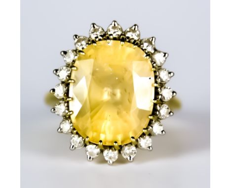 A Sapphire and Diamond Ring, 20th Century, 15ct gold set with a centre yellow sapphire, approximately 17ct, surrounded by rou