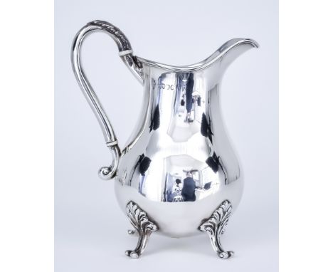 A Victorian Silver Baluster Shaped Jug by Charles Stuart Harris, London, 1889, with reeded rim and leaf capped scroll handle,