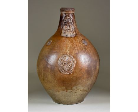 A German Saltglazed Stoneware Bartmannkrug, 17th Century, with moulded bearded mask, oval cartouche and two small roundels to