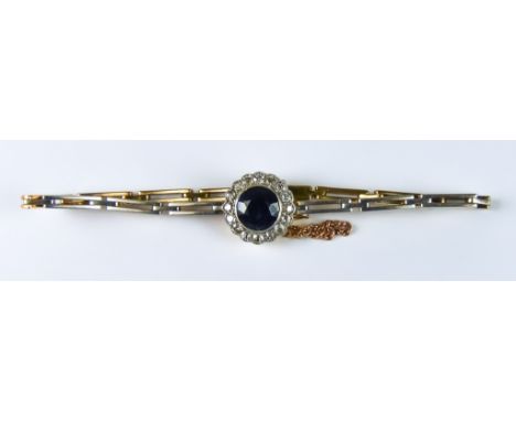 A Sapphire and Diamond Bracelet, Modern, yellow metal set with a centre sapphire, approximately 1.5ct, surrounded by 16 small