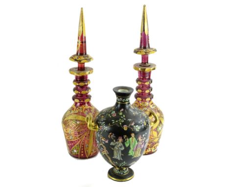 A pair of Bohemian style ruby tinted decanters, each with a Middle Eastern style coloured enamel decoration, 49.5cm H and a C