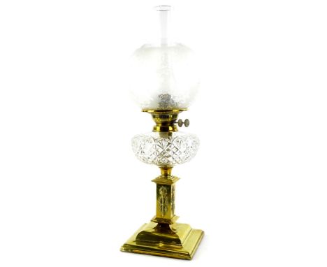 A Victorian brass oil lamp, with a part frosted shade, cut glass reservoir, the base decorated with flaming torch and stepped