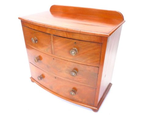 A Victorian mahogany bow fronted chest, the top with a raised back and a moulded edge above two short, two long drawers each 