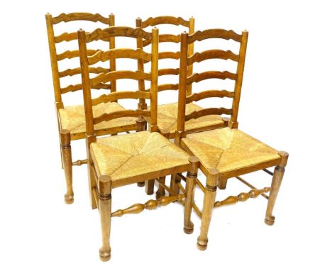 A set of four Lancashire type ladder backside chairs, each with a rush seat, turned tapering legs and pad feet.