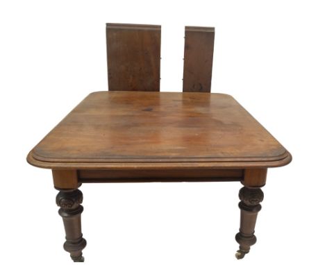 A Victorian mahogany pull out dining table, with double moulded top, scroll carved and matted taper turn legs, on brass and c