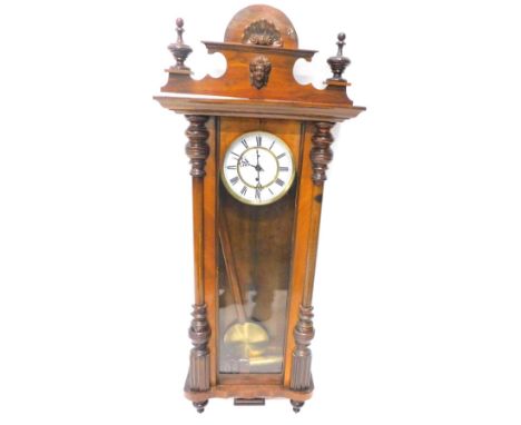 A late 19th/early 20thC Vienna walnut wall clock, the shaped crest applied with a female mask, the enamel dial with Roman num