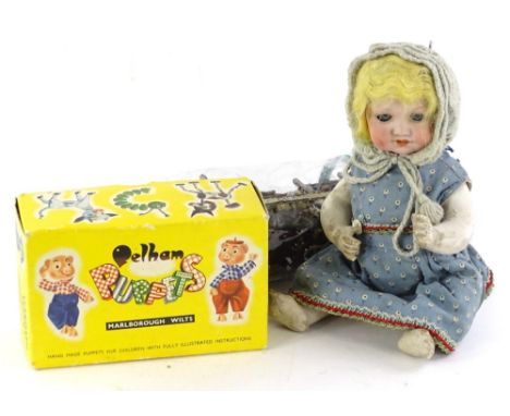 A German bisque headed doll, with composition limbs, (AF), a Pelham Bengo puppet in original box.