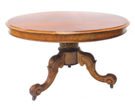A mahogany coffee table, the circular top with a moulded edge on a short leaf carved column and splayed legs with ceramic cas