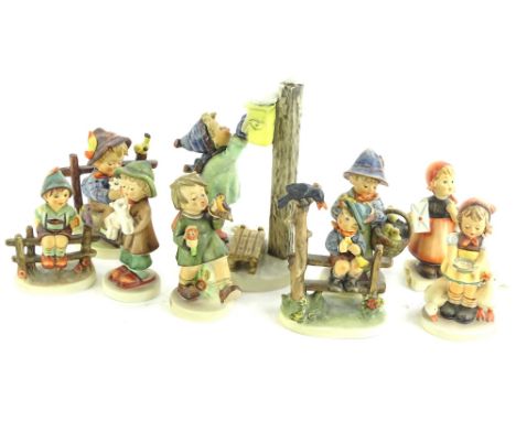 A collection of Goebel Hummel figures, to include boy on a fence, boy with a flower and bird, posting a letter etc. (9)