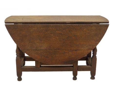 An early 18thC oak gate leg table, with oval drop leaf top, frieze drawer, baluster turned legs and feet, square framing, 75c