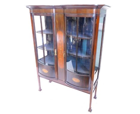 An Edwardian mahogany display cabinet, the moulded cornice above two glazed bow fronted doors, flanking a central satinwood a
