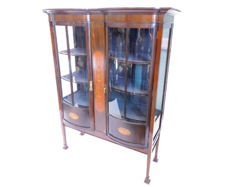 An Edwardian mahogany display cabinet, the moulded cornice above two glazed bow fronted doors, flanking a central satinwood a