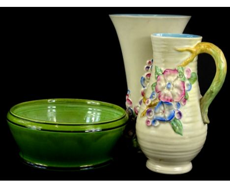 A Clarice Cliff relief moulded floral ewer or jug, with ribbed body, tapering vase, a similar vase of tapering form and a Bre