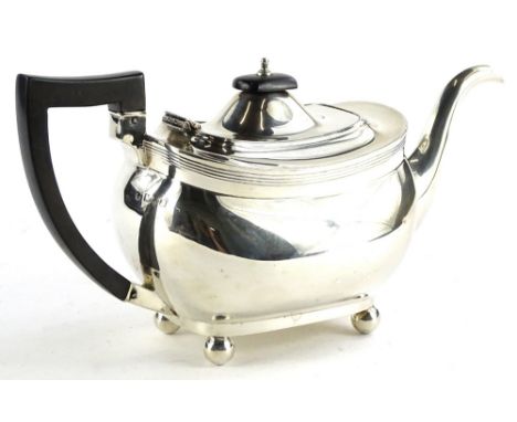 An Edwardian silver teapot, of rectangular form with reeded band top, ebonised knop and handle on bun feet, marks indistinct,