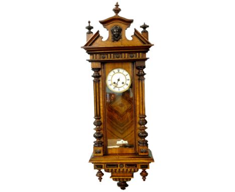 A late 19thC Vienna wall clock, in a walnut case, the crest decorated with a composition mast above enamel dial, flanked by r