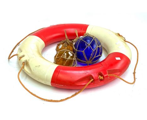 A large blue glass fisherman's float, two smaller amber glass floats, wooden ships wheel, and vintage life ring 