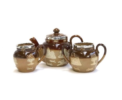 A miniature Royal Doulton Lambeth Stoneware tea set, comprising teapot, 10.5cmH, milk jug, and sugar bowl with two handles, a