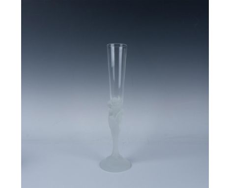 A clear glass with a frosted stem featuring the faces of seven women intertwined and flowing to the base. Erte engraved at ba