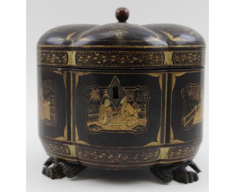 A 19th century Chinese export lacquer tea caddy of lobed form, with gilded chinoiserie decoration, raised on three carved woo