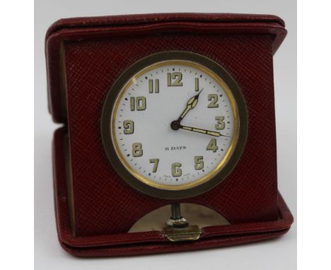 An early to mid 20th century travelling clock, fitted 8-day Swiss movement, folding within a red leather case, the dial 5cm, 
