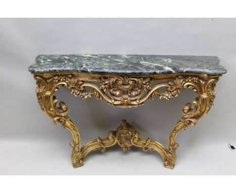 A Continental design carved gilt wooden console table, having green marble top, floral base section supported on twin legs, u