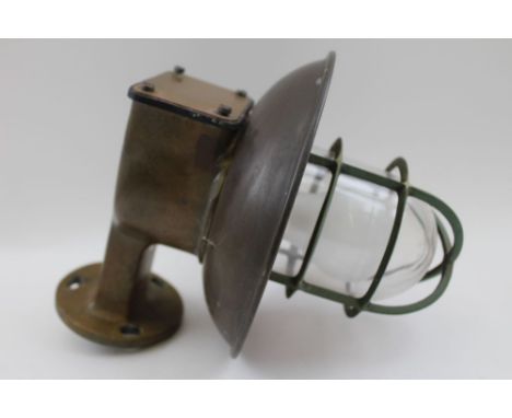 A brass framed ships bulkhead lamp, with cage protector and clear glass lens, the shade 20cm in diameter 