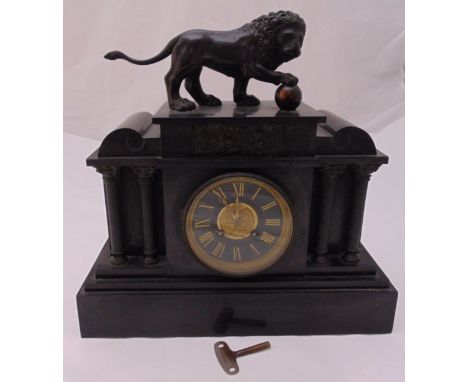 A late Victorian black slate mantle clock of architectural form with black dial and Roman numerals, two train movement surmou