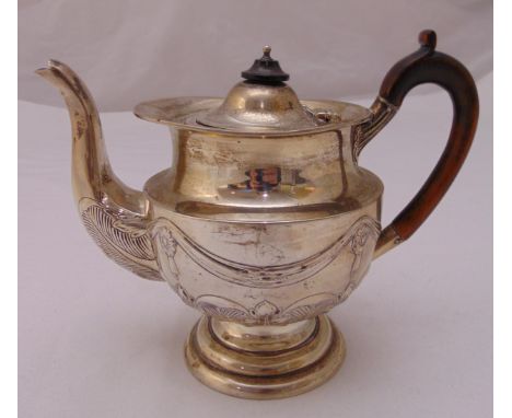 A hallmarked silver teapot, cylindrical chased with stylised leaves, swags and rosettes, with fruitwood handle on raised circ