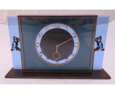 An Art Deco brass and glass rectangular eight day mantle clock, Arabic numerals with cast metal stylised bird figurines to th