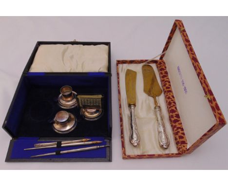 A hallmarked silver cased pen and inkwell set and a cased set of white metal and brass servers