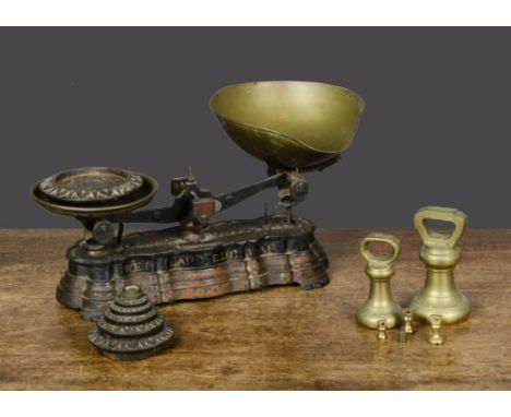A pair of cast-iron weighing scales,  with stepped base ‘W.E. FO? LARD EDG?WARE’ in gold letters along side, brass pans —14in