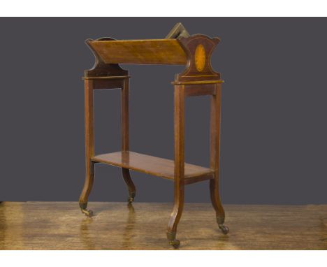 A small portable library shelf circa 1900, Sheraton-style, inlaid mahogany, on brass and pottery casters —24½in. (62cm.) high