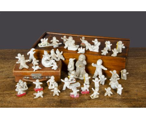 Bisque Snow Baby cake decorations, forty including three moulded holding hands —3½in. (9cm.) long, six with sleighs, one play