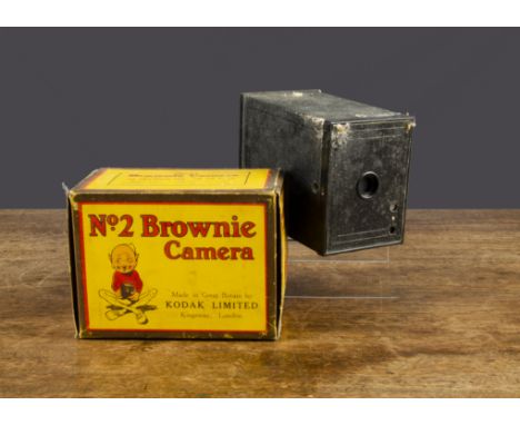 An Eastman Kodak Co Brownie Camera No 2,  instructions, In original yellow box illustrated with a Brownie —5¾in. (14.5cm.) lo
