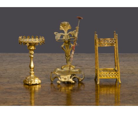 Gilt metal dolls’ house items, an Art Nouveau umbrella stand —3in. (7.5cm.) high; another umbrella stand and a lamp base (mis