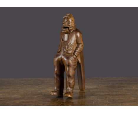 A French carved wooden elderly man nutcracker, the bearded figure standing with his hand in pockets and lever action —8in. (2