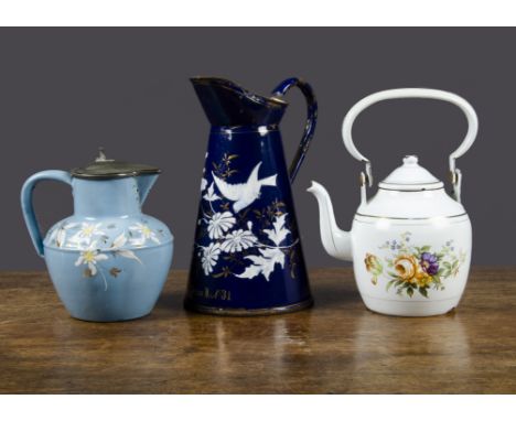 Three enamel vessels, a dark blue water jug decorated with clematis and a bird —9½in. (24cm.) high; a light blue hot-water ju