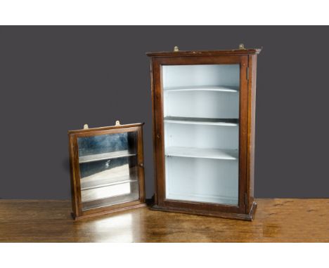 Two wall-mounted display cabinets, both front-opening with shelves —30in. (76cm.) high (one shelf warped) and the smaller, wi